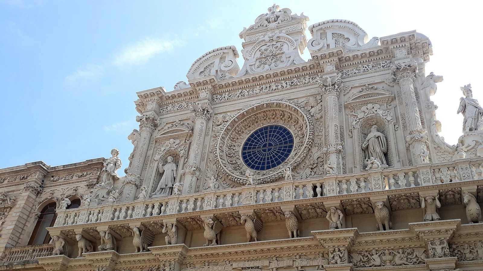 La facciata barocca della basilica di Santa Croce a Lecce, con il grande rosone e le statue scolpite nella pietra leccese